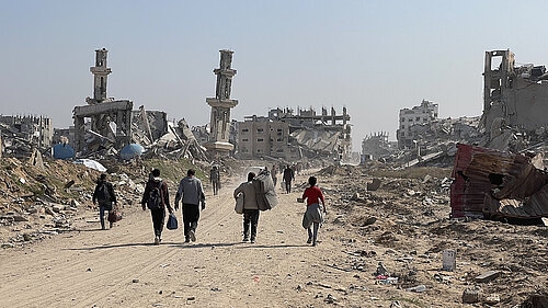 Group of people walking down destroyed areas in Gaza