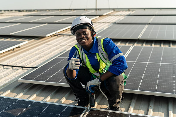 A man putting solar panels on a roof.