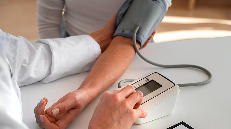 A doctor takes somebody's blood pressure.