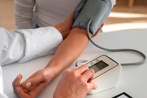 A doctor takes somebody's blood pressure.