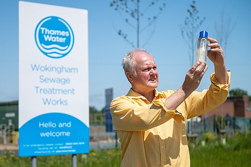 Clive looking at a sample of dirty looking water outside Thames Water