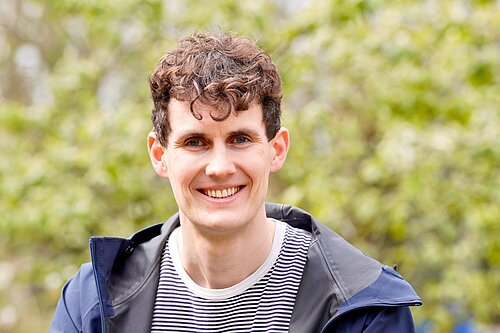 Josh Matthews in front of a green background