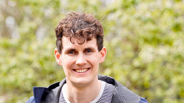 Josh Matthews in front of a green background
