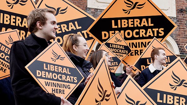 A group of Lib Dem activists with big placards