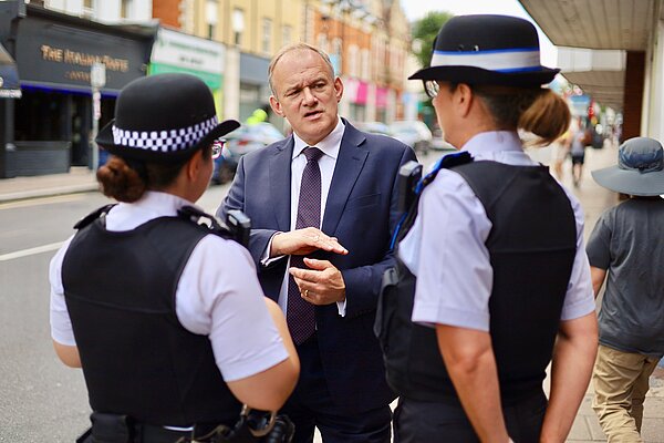 Ed Davey MP talking to two police officers